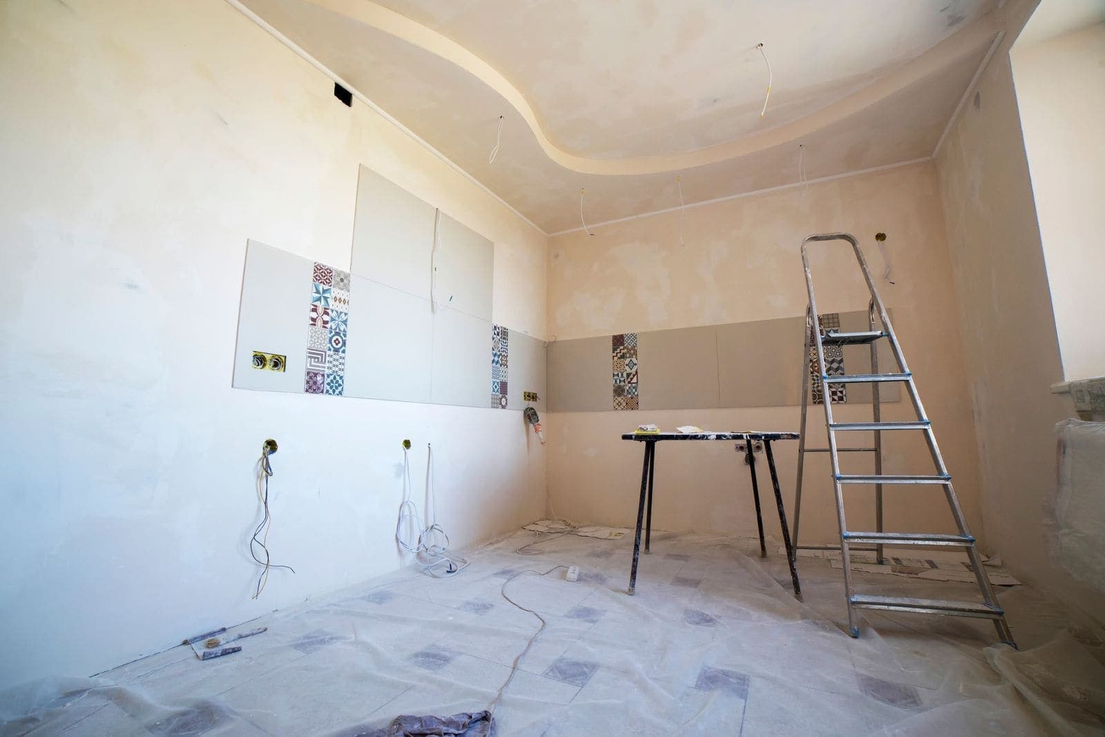 After: Bright empty room with new drywall and a ladder after repairs